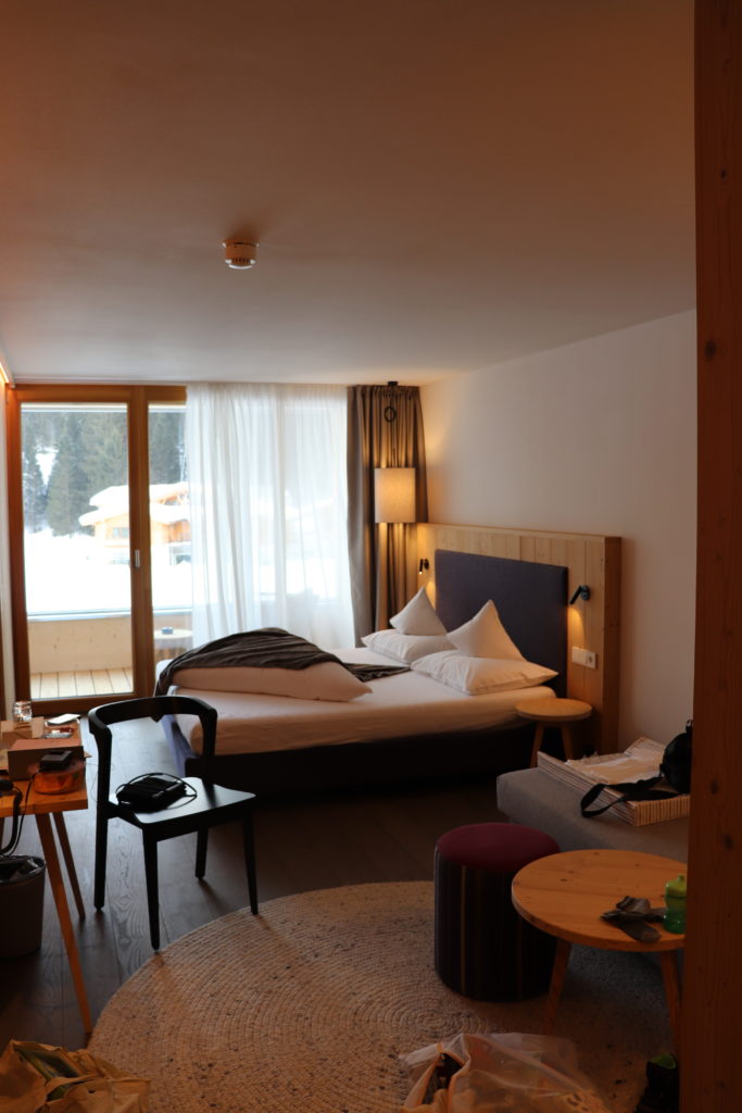 Hotelzimmer aus Holz mit Bett und Sitzecke