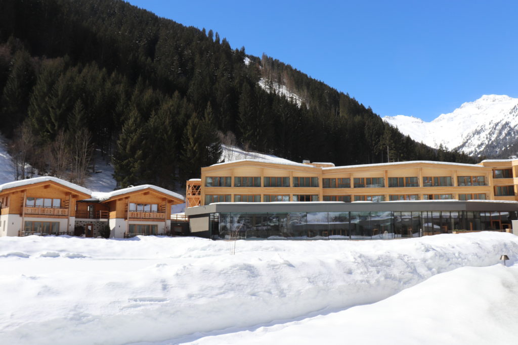 Gesamtansicht des Resorts im Schnee vor den Bergen