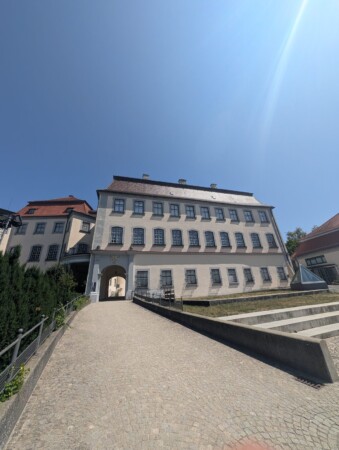 Vorderansicht von Schloss Großlaupheim mit Torbogen und Auffahrt