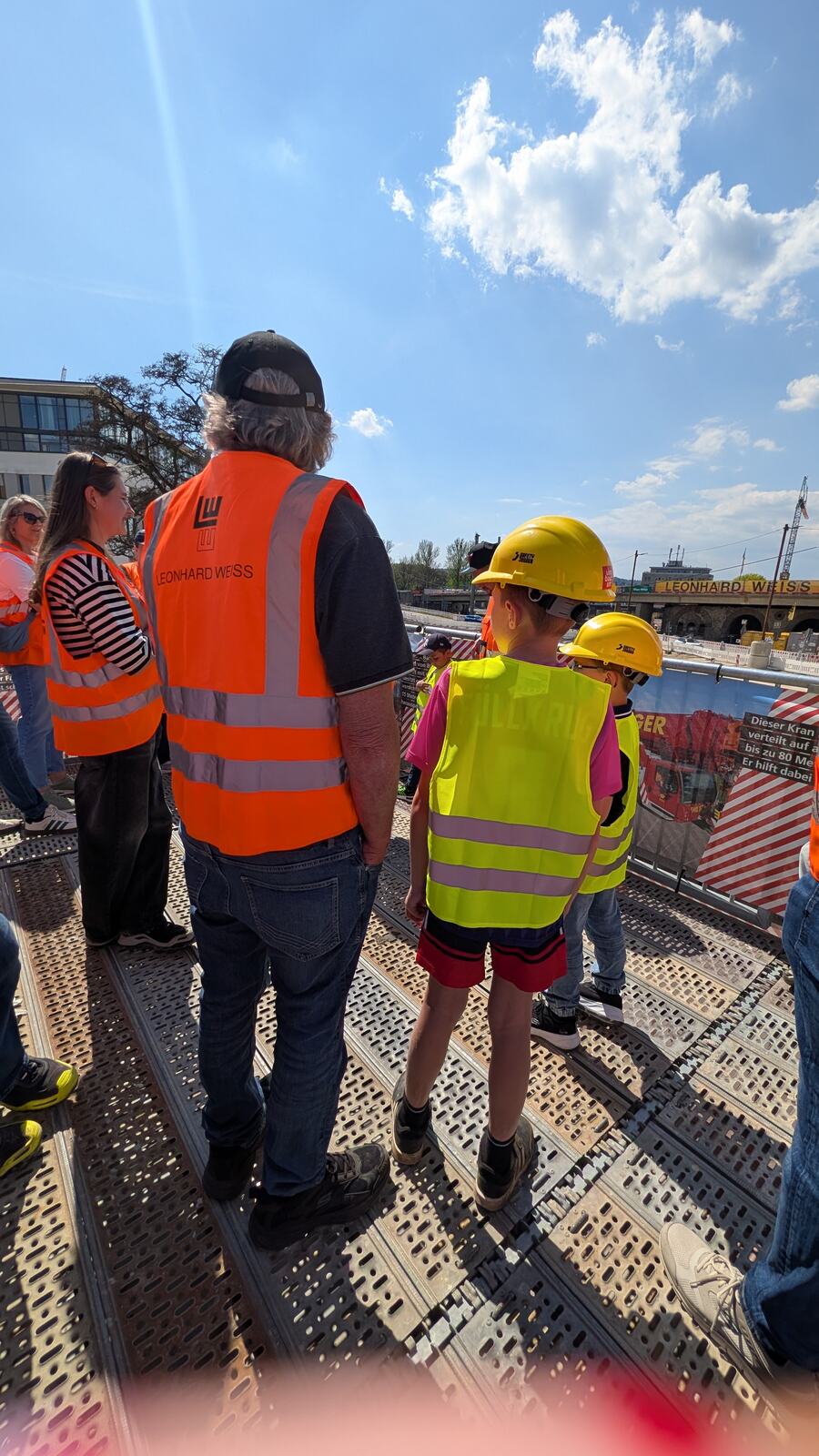 Gruppe mit Warnwesten und Helmen auf der Baustelle