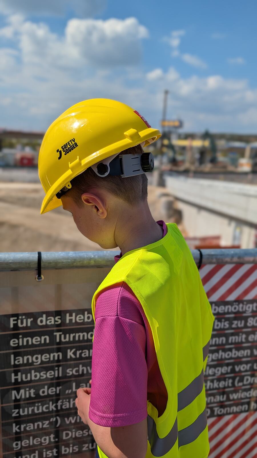 Kind mit gelbem Bauhelm auf der B10-Baustelle