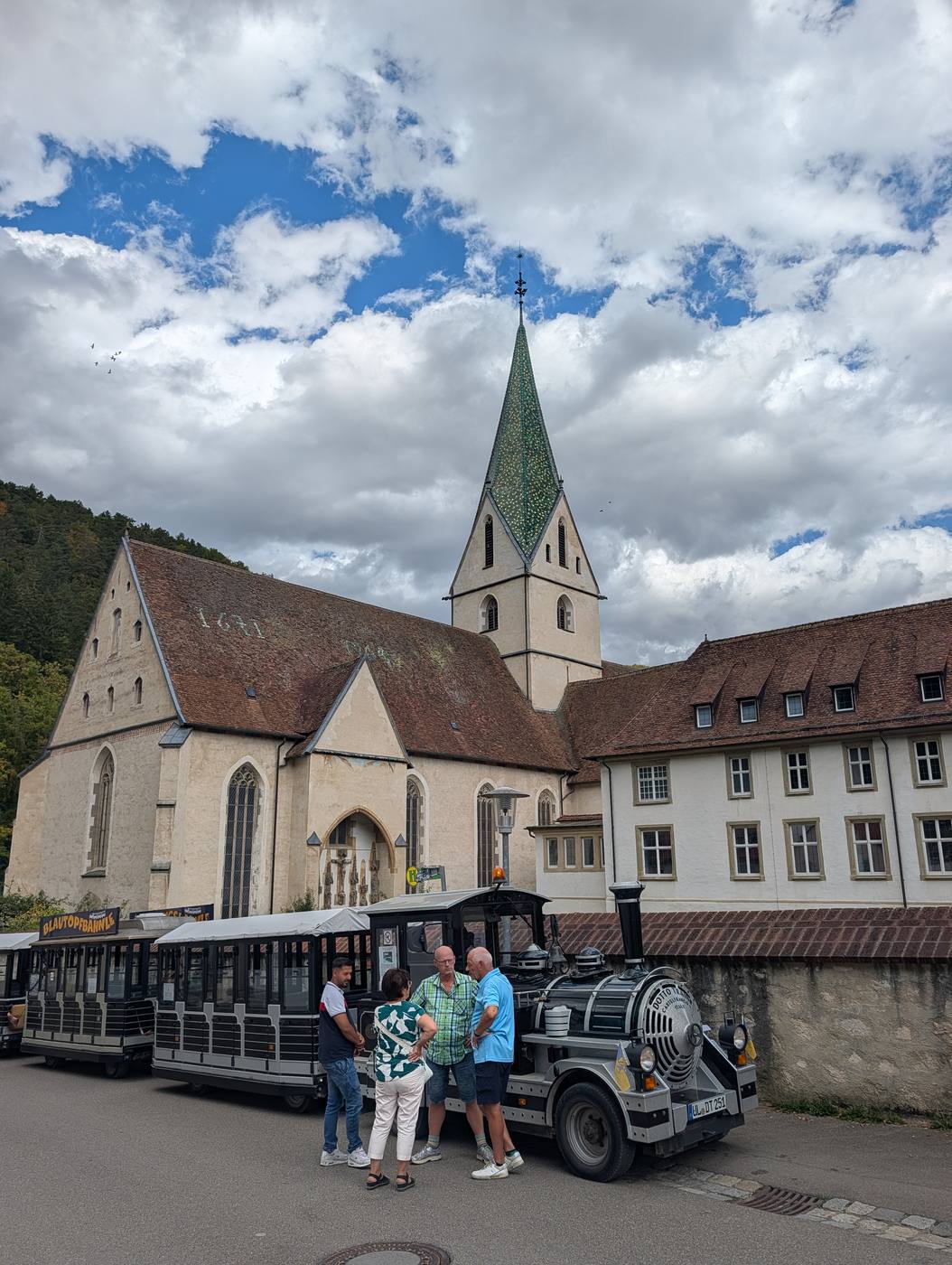 Das Kloster Blaubeuren mit dem gr&uuml;n glasierten Kirchturm, davor das Blautopfb&auml;hnle