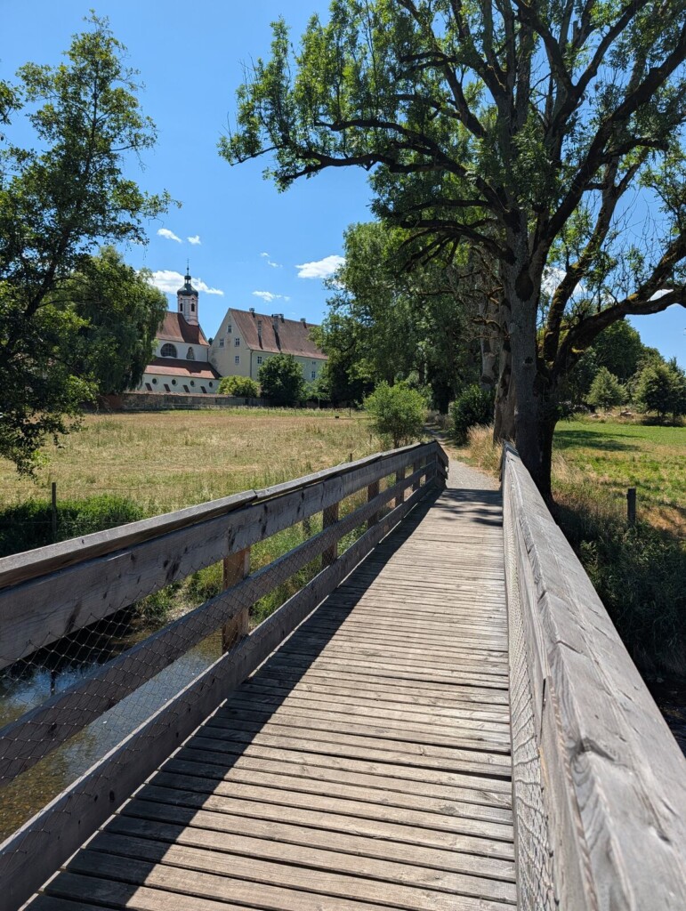 Holzsteg mit Blick auf das Kloster Gutenzell