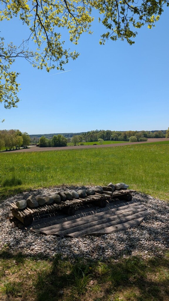 Installation aus Baumstaemmen am Wegrand
