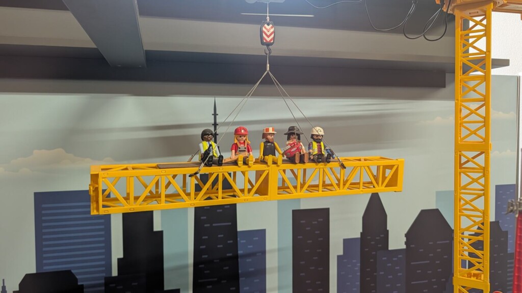 Baustellen-Diorama mit Kran ueber der Stadt