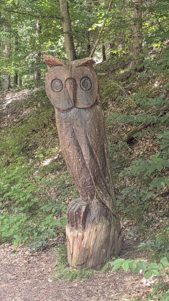Geschnitzte Eule auf einem Baumstamm