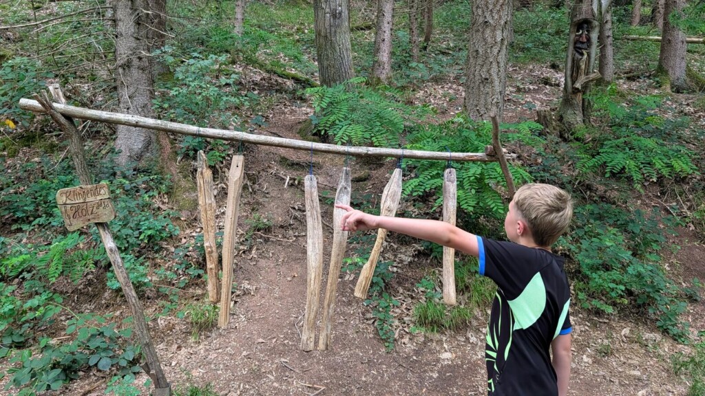 Kind an einem Balancierbalken im Wald
