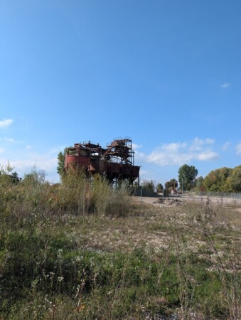 Ehemaliges Kieswerk Vollmer hinter einer Wildwiese im Donaumoos