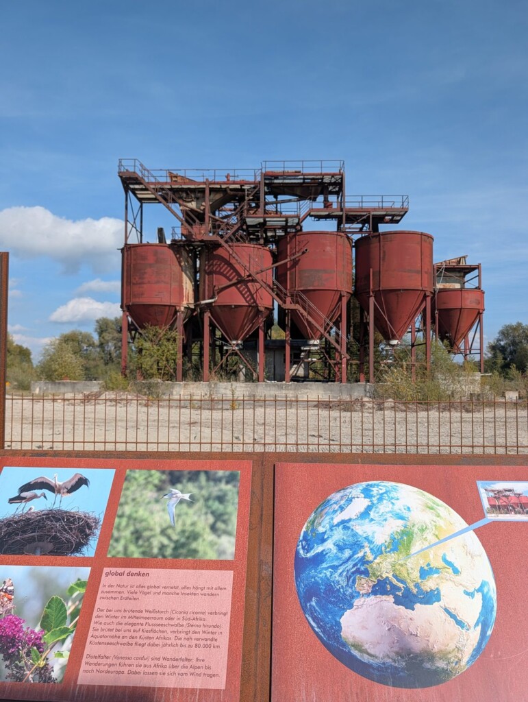 Rostrote Silos der Landmarke Donaumoos mit Infotafel der Ausstellung