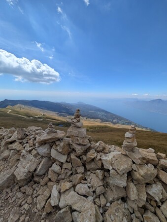 Steinmännchen auf einer Mauer am Monte Baldo mit Blick nach Süden über den Gardasee