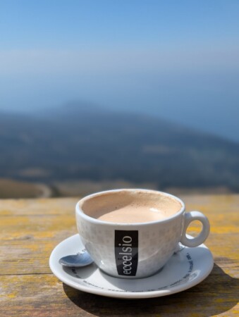 Cappuccino auf dem Holztisch einer Berghütte am Monte Baldo