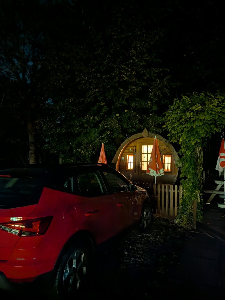 Beleuchtetes Schlaffass bei Nacht auf dem dunklen Campingplatz