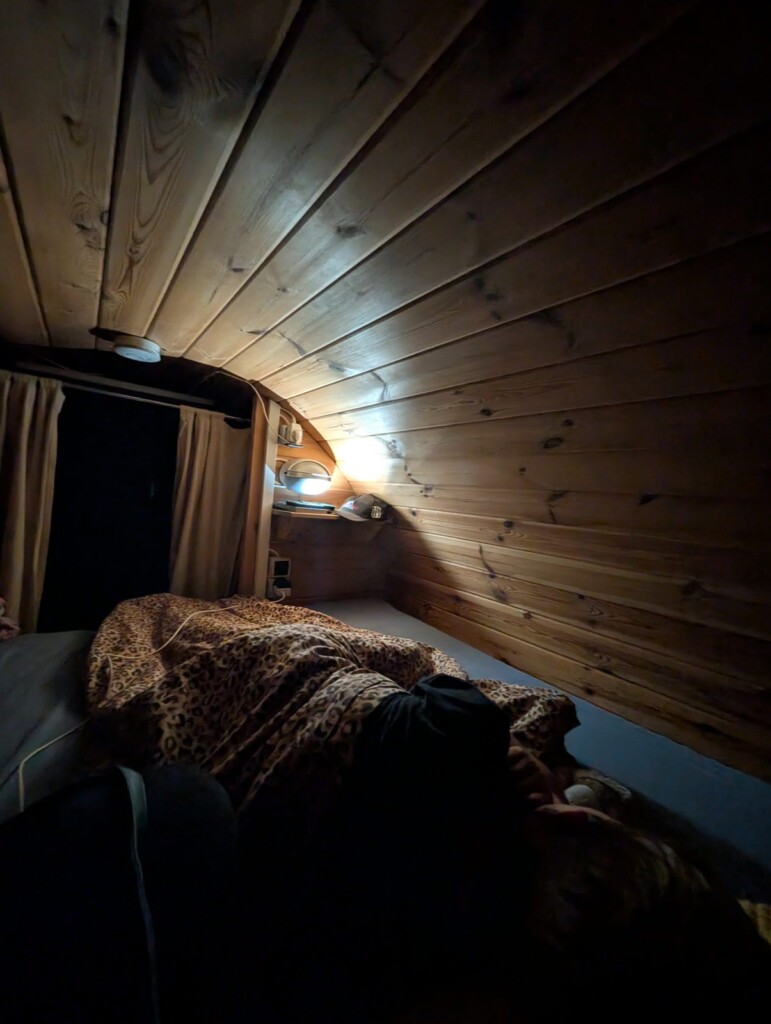 Schlaffass innen bei Nacht, nur eine kleine Leselampe am Bett