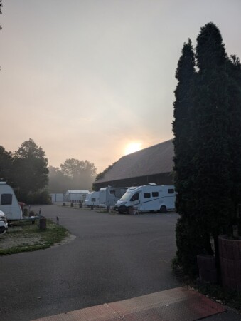 Sonnenaufgang im Nebel über den Wohnmobil-Stellplätzen am Gutshof Donauried
