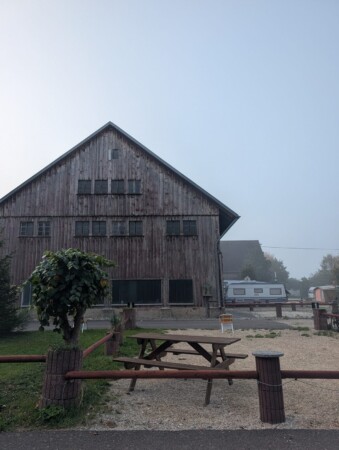 Alte Holzscheune des Gutshofs mit Picknicktisch auf dem Campingplatz